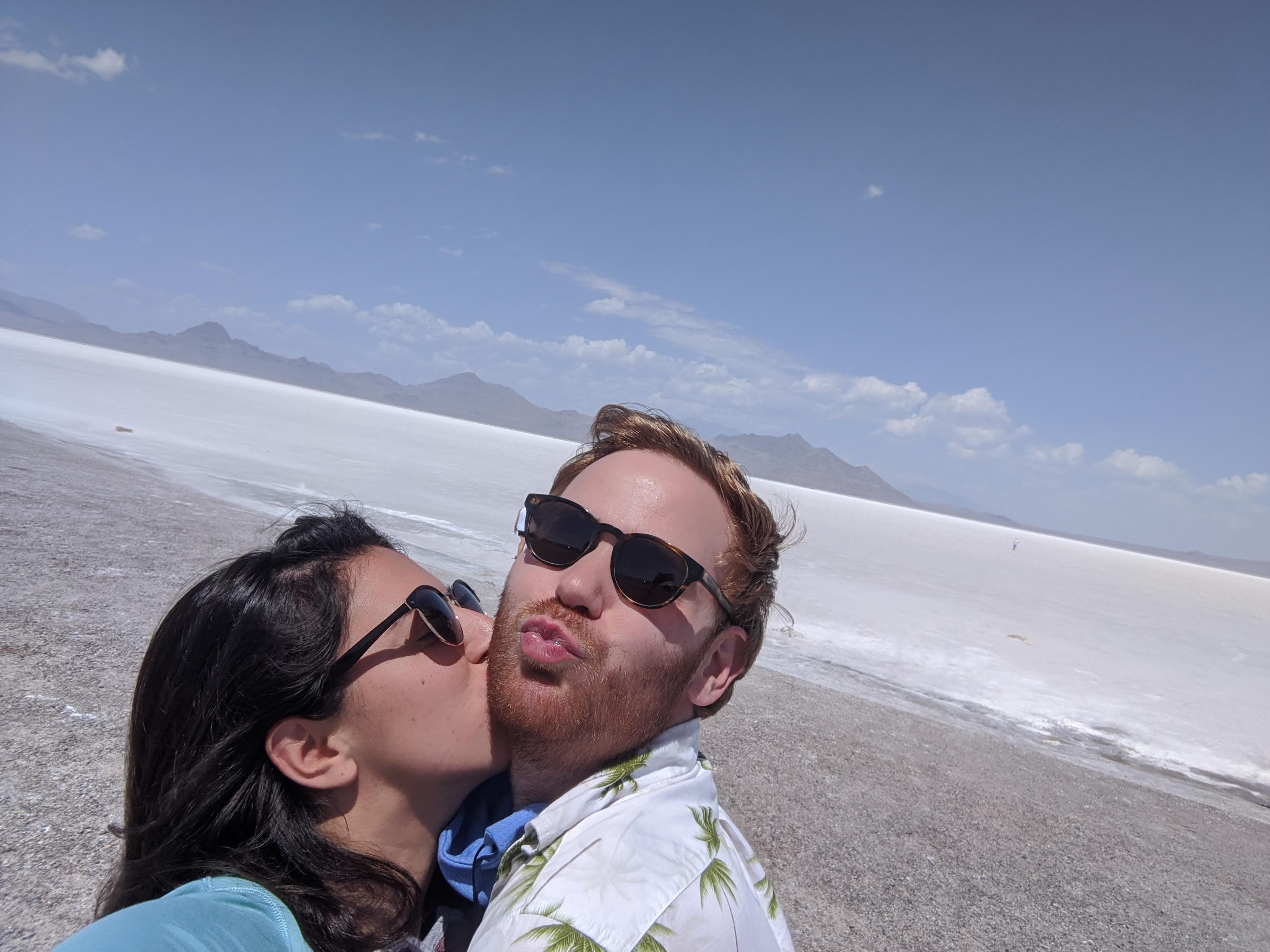 Ariana and Erik kissing in front of a salt flat in Utah